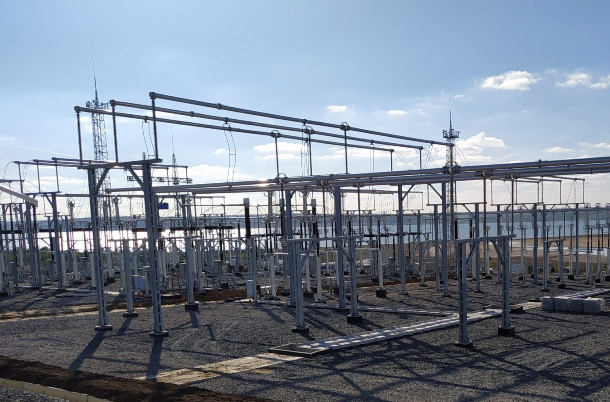 An outdoor 330 kV switchyard, with steel lattice structures carrying conductors above rows of high-voltage equipment.