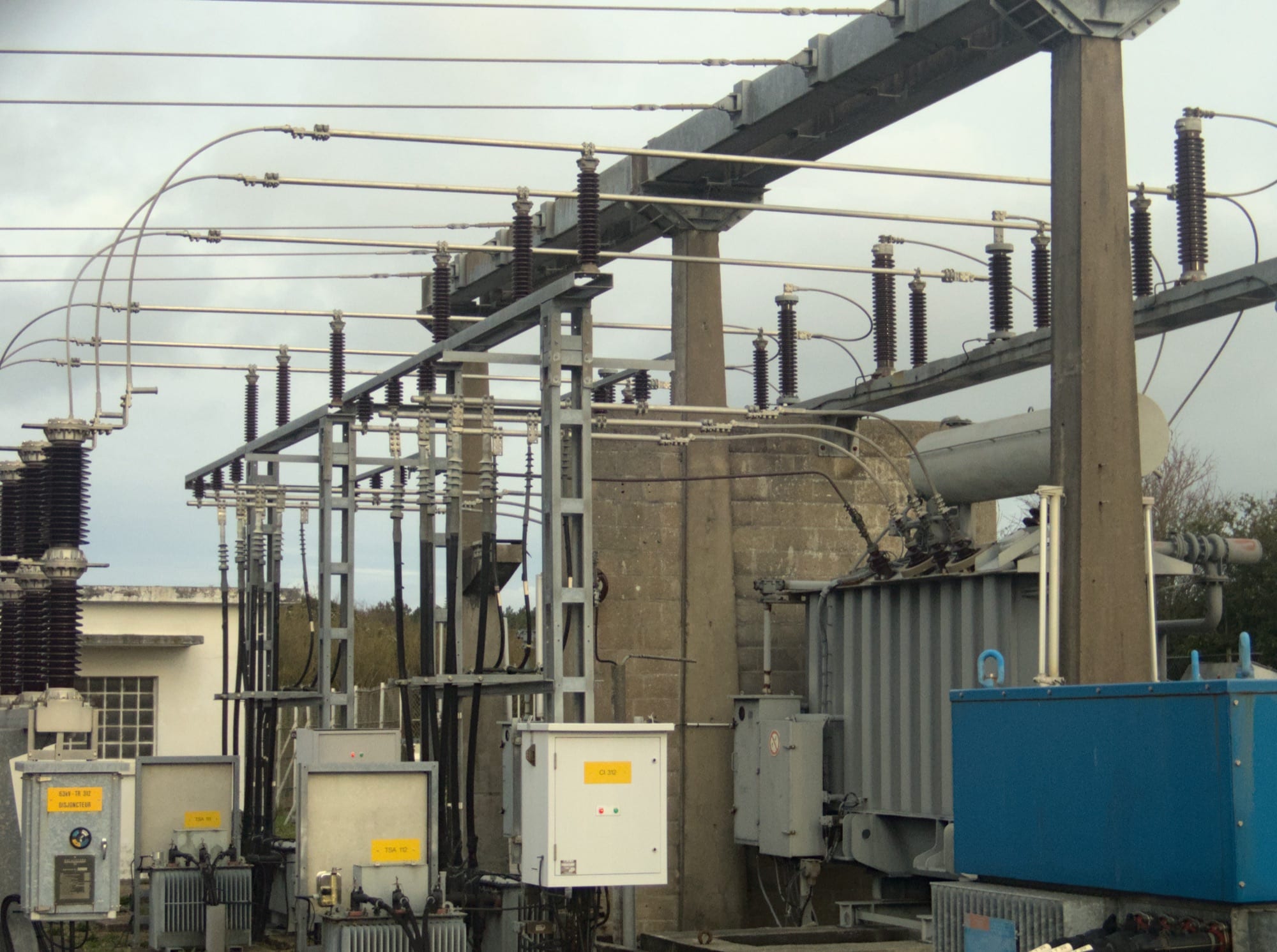 Overhead conductors at two different voltage levels connecting down to a substation transformer.